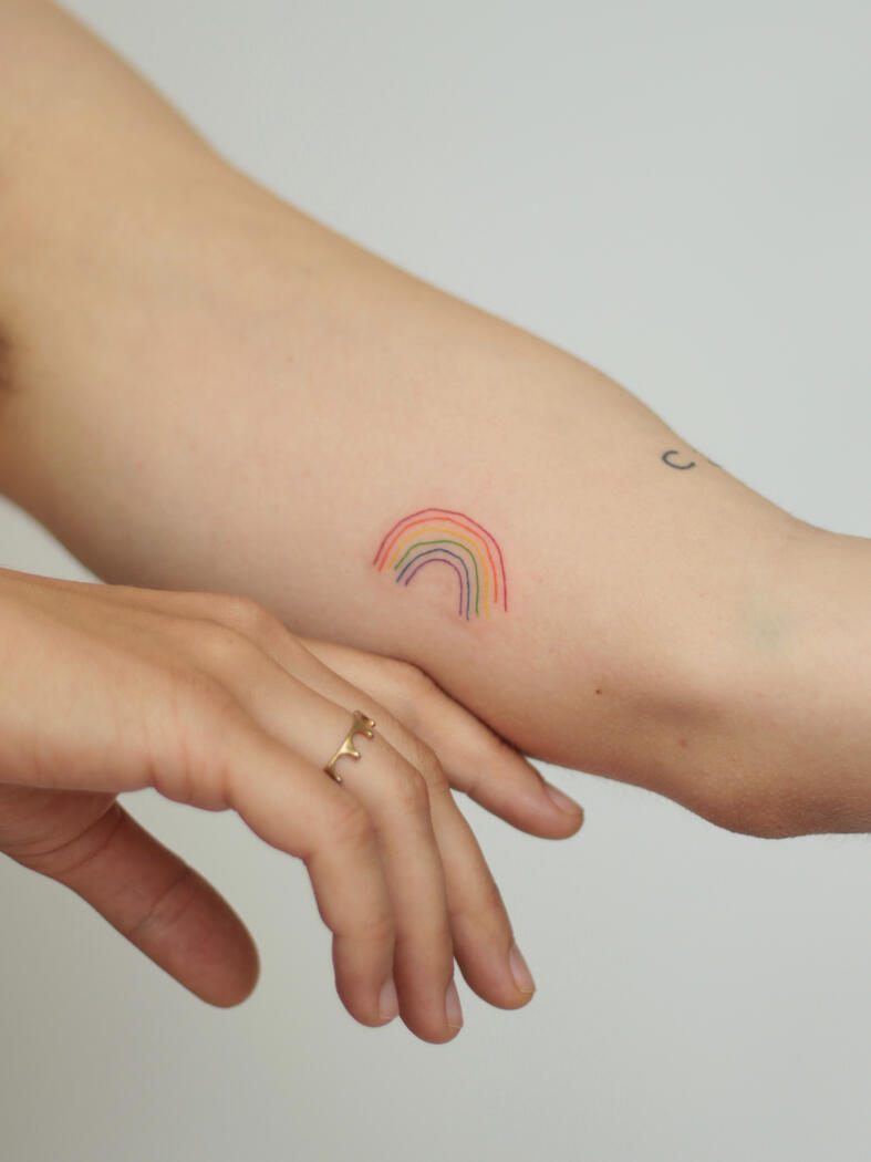 Fine line rainbow tattoo by queer artist in lisbon